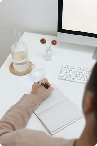 Person writing course outline in a notebook