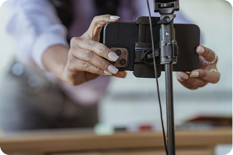 Hands setting up a smartphone on a tripod for recording