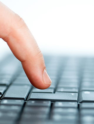 Finger pressing a key on a keyboard, symbolizing submission